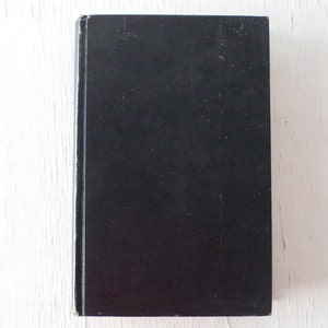 May include: A black hardcover book with a plain cover.