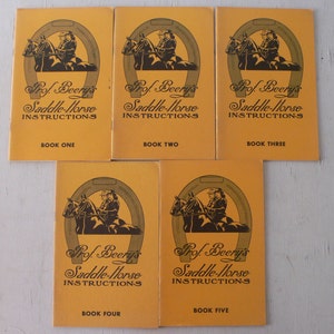 May include: Five vintage saddle-horse instruction books. Each book has a yellow cover with a horseshoe and rider illustration. The text reads "Prof. Beery's Saddle-Horse Instructions" with the book number below. Books include: Book One, Book Two, Book Three, Book Four, and Book Five.
