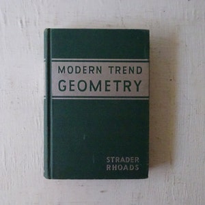 May include: A green hardcover book titled "Modern Trend Geometry" by Strader Rhoads.
