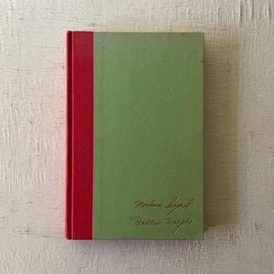 May include: A green hardcover book with a red spine. The book has the title "Modern Sigal" written on the front cover in cursive.