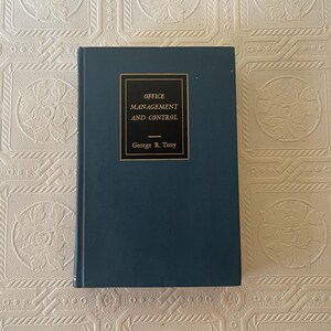 May include: A hardcover book titled "OFFICE MANAGEMENT AND CONTROL" by George R. Terry. The book has a dark teal cover with a gold-framed title box. The title and author's name are in white text.