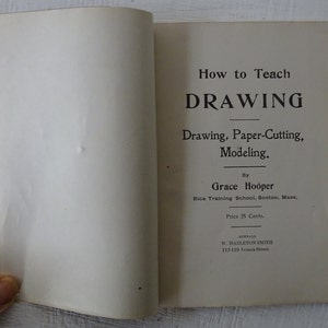 Peut inclure: Une couverture de livre vintage intitul&eacute;e "How to Teach DRAWING" avec le sous-titre "Drawing, Paper-Cutting, Modeling." Le livre a &eacute;t&eacute; &eacute;crit par Grace Hooper de la Rice Training School &agrave; Boston, Massachusetts. Le livre a &eacute;t&eacute; publi&eacute; par W. Hazleton Smith &agrave; Buffalo, New York.
