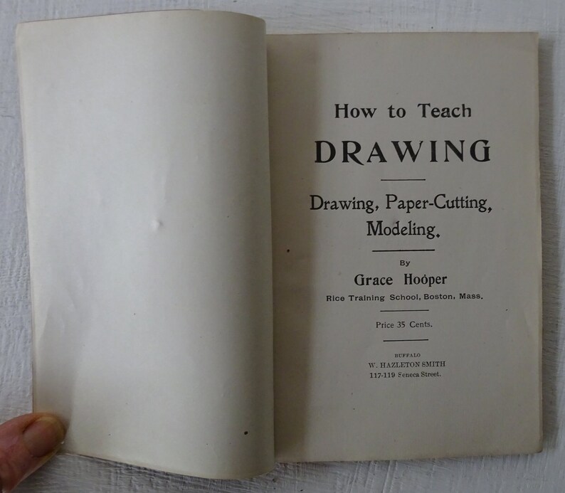 Peut inclure: Une couverture de livre vintage intitul&eacute;e "How to Teach DRAWING" avec le sous-titre "Drawing, Paper-Cutting, Modeling." Le livre a &eacute;t&eacute; &eacute;crit par Grace Hooper de la Rice Training School &agrave; Boston, Massachusetts. Le livre a &eacute;t&eacute; publi&eacute; par W. Hazleton Smith &agrave; Buffalo, New York.