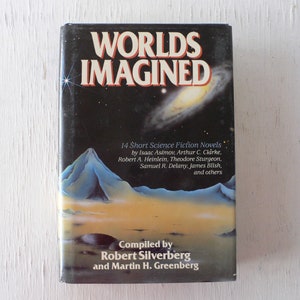 May include: A black book with the title "Worlds Imagined" in white and gold lettering. The book cover features a colorful illustration of a mountain range and a galaxy in the night sky. The book is a collection of 14 short science fiction novels by authors such as Isaac Asimov, Arthur C. Clarke, and Robert A. Heinlein.