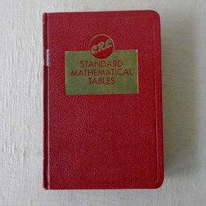 May include: A red hardcover book with a gold label that reads "CRC Standard Mathematical Tables".