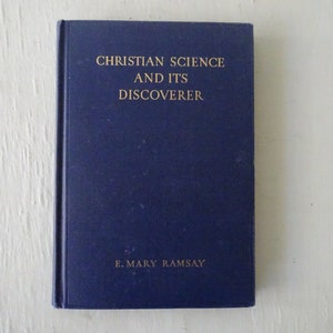 May include: A blue hardcover book with the title "Christian Science and Its Discoverer" and the author "E. Mary Ramsay" printed in gold lettering.