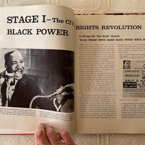 Puede incluir: Un libro abierto con lomo rojo, con una fotograf&iacute;a en blanco y negro de Martin Luther King Jr. hablando. El texto dice "STAGE I - The Civil Rights Revolution" y "BLACK POWER". Tambi&eacute;n es visible un cartel de una manifestaci&oacute;n de Chicago Freedom.