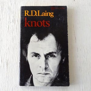 May include: A black and white photo of R.D. Laing on the cover of his book "knots".