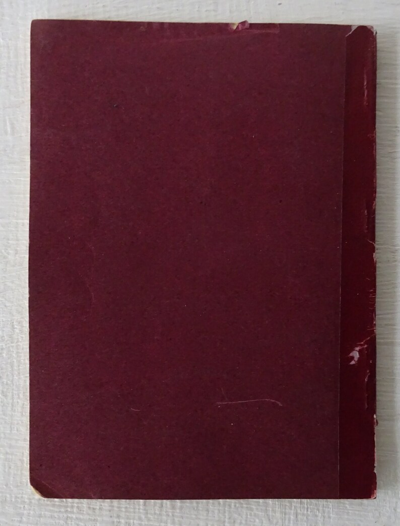 Peut inclure: Un livre de couleur bordeaux avec une reliure rouge. Le livre est ferm&eacute; et a une couverture textur&eacute;e.