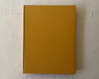 May include: A solid yellow hardcover book with a smooth, textured cover.