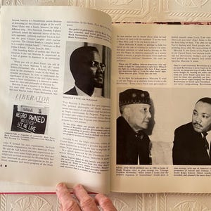 Puede incluir: Un libro abierto con fotograf&iacute;as en blanco y negro y texto. La p&aacute;gina izquierda presenta un recorte de peri&oacute;dico con el texto "NEGRO OWNED BROTHER LET ME LIVE". La p&aacute;gina derecha tiene una foto de Martin Luther King Jr.