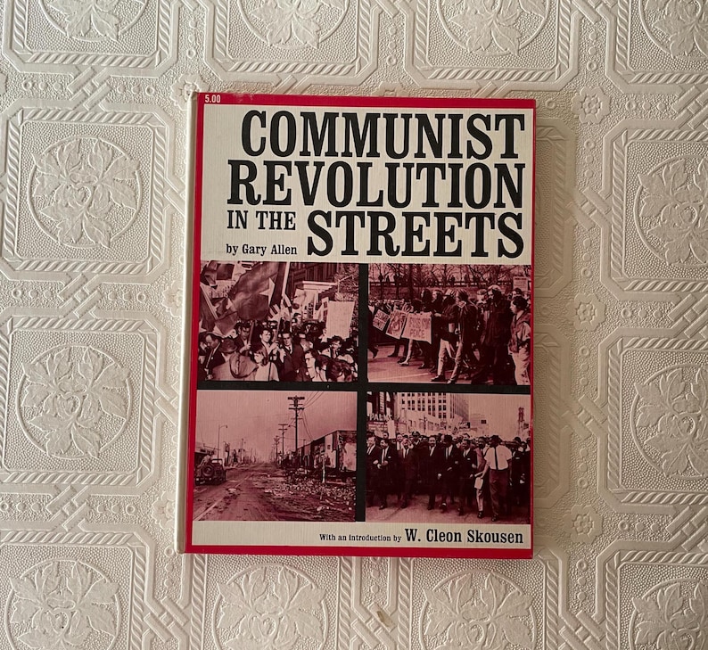 Puede incluir: Un libro titulado "COMMUNIST REVOLUTION IN THE STREETS" de Gary Allen. La portada tiene un borde rojo y texto negro. El libro incluye im&aacute;genes de multitudes y escenas callejeras. El precio de 5,00 es visible en la esquina superior izquierda.