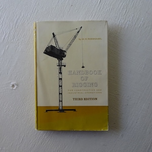 May include: A yellow and black book titled "Handbook of Rigging" by W.E. Rossnagel. The book is about construction and industrial operations. It is the third edition.