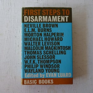 May include: A blue book titled "First Steps to Disarmament" with the names of the authors and editor listed on the cover. The book is published by Basic Books.