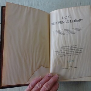 May include: A vintage book titled "I.C.S. Reference Library" with a list of drawing courses: Geometrical Drawing, Projection Drawing, Freehand and Ornamental Drawing, Wash Work and Brush Drawing, Elementary Perspective Drawing, and Architectural Drawing. The book has a number "378986" printed on the bottom right corner.