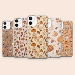 May include: Five phone cases with autumn-themed designs. The cases feature pumpkins, leaves, coffee mugs, and other fall elements in shades of orange, brown, and beige. The cases are designed for a smartphone.