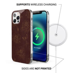 May include: A brown phone case with a floral design and a clear border. The phone screen displays a charging symbol, indicating wireless charging. The text "SUPPORTS WIRELESS CHARGING" and "SIDES ARE NOT PRINTED" are visible.