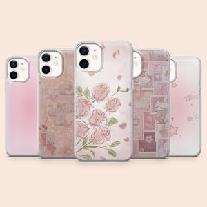 May include: Five phone cases with different designs. The cases are clear with various pink and pastel designs, including roses, stamps, and stars. The cases are arranged in a row, showcasing the variety of available styles.