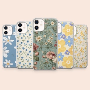 Op de afbeelding: Vijf smartphonehoesjes op een rij, elk met een eigen bloemenpatroon. De ontwerpen omvatten grote witte madeliefjes op blauw, kleine blauwe bloesems op crème, een vintage botanische print op saliegroen, grote gele en blauwe bloemen en kleine gele wilde bloemen op wit.