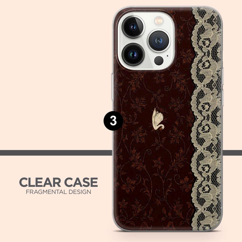 May include: A clear phone case with a dark brown floral pattern and a gold swan emblem. The right side features a beige lace design. The text "CLEAR CASE FRAGMENTAL DESIGN" is at the bottom.
