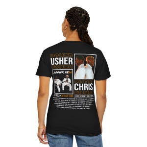 May include: A black t-shirt featuring a graphic on the back with the text USHER and CHRIS. The design includes two photographic panels of the artists, the text SUMMER 2026, THE R&B TOUR, and a list of tour dates and locations in white and gold.