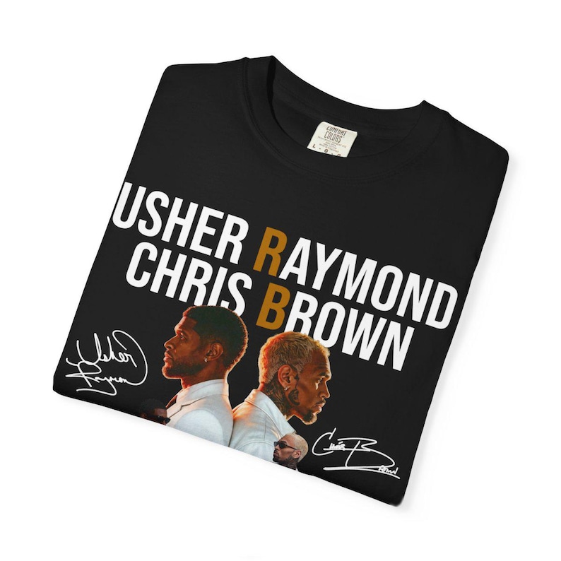 May include: A black t-shirt featuring the white text USHER RAYMOND CHRIS BROWN with a gold letter B in the center. Below the text are photographic portraits of Usher and Chris Brown in white suits, accompanied by their printed signatures in white.