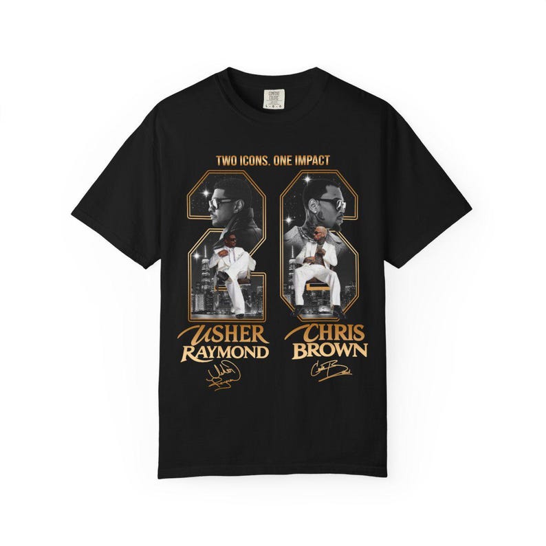 May include: A black short-sleeve t-shirt featuring a graphic print with the text "TWO ICONS. ONE IMPACT" above two framed portraits of Usher Raymond and Chris Brown. Each portrait includes the artist's name and a signature in gold lettering.