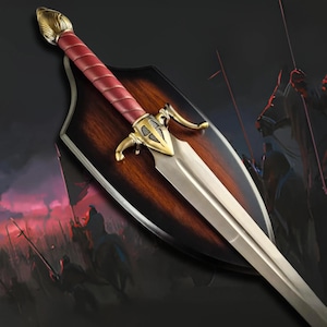 May include: A decorative sword mounted on a dark wood shield-shaped plaque. The sword features a metallic silver blade, a gold-toned metal crossguard with intricate detailing, and a handle wrapped in deep red material with a gold pommel.