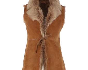 May include: A sleeveless brown suede vest with a faux fur collar and trim. The vest has a tie closure at the waist and a soft, textured appearance. The fur trim is a lighter shade of brown, creating a contrast with the suede.