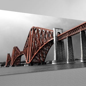 May include: A canvas print depicting the Forth Bridge in Scotland. The bridge is rendered in a striking combination of red and grey, with the intricate metal structure of the bridge set against a grey sky and water. The image is in landscape format.