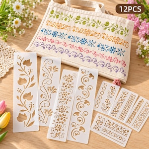May include: A set of 12 translucent plastic stencils featuring various floral, vine, and geometric border patterns. The stencils are displayed alongside a beige canvas storage pouch printed with four colourful horizontal floral border designs.