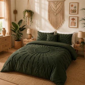 May include: A dark green bedspread and pillow set with a sunburst design. The bedroom features a woven rug, wooden furniture, and decorative wall hangings. The room is decorated in neutral tones with plants.