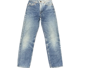 May include: Light blue denim jeans with a faded wash. The jeans have a classic five-pocket design, a button and zipper closure, and a straight leg fit. The denim has a slightly worn appearance.
