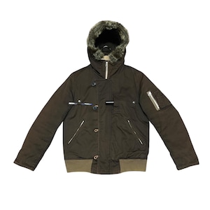 Könnte beinhalten: Braune Winterjacke mit fellgefütterter Kapuze. Die Jacke hat einen Reißverschluss, mehrere Taschen und Knöpfe. Die Manschetten und der Saum sind olivgrün.