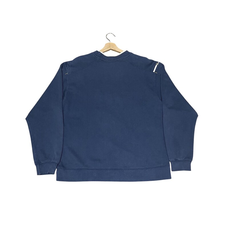 Puede incluir: Una taza de cer&aacute;mica blanca con asa negra y el texto "But First, Coffee" en negro y negrita. La taza est&aacute; sobre una superficie de madera.