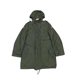 May include: An olive green military-style jacket with a hood, button-up front, and multiple pockets. Features German flag patches on the shoulders. The jacket has a drawstring at the waist and buttoned cuffs.