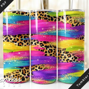 Peut inclure: Trois gobelets en acier inoxydable avec un design vibrant. Le motif présente des coups de pinceau colorés dans les tons de bleu, jaune, rose et violet, entrecoupés d'imprimé léopard. Les gobelets sont décorés d'accents de paillettes dorées.