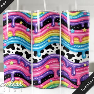 Puede incluir: Tres vasos de acero inoxidable con un diseño vibrante y colorido. El diseño presenta un patrón de arcoíris con pintura goteando, estrellas y un estampado de vaca en blanco y negro. Los vasos tienen un diseño sin costuras y están etiquetados como envolturas de vasos.