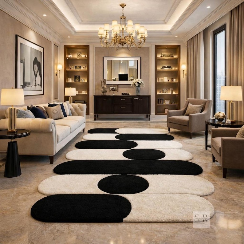 K&ouml;nnte beinhalten: Ein modernes Wohnzimmer mit einem cremefarbenen Sofa, Sesseln und einer Reihe von ovalen Teppichen in Schwarz und Creme. Der Raum wird von einem Kronleuchter und Lampen beleuchtet, mit Einbauregalen und einem dunklen Holzschrank. Die Teppiche sind etwa 200 cm lang.