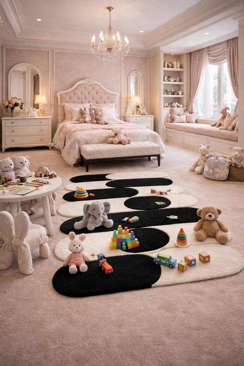 K&ouml;nnte beinhalten: Ein rosa Schlafzimmer mit einem gro&szlig;en Bett, einer Bank und passenden M&ouml;beln. Auf dem Boden liegen ovale schwarz-wei&szlig;e Teppiche, auf denen Spielzeug und Stofftiere verstreut sind. Eine Leuchte h&auml;ngt von der Decke.