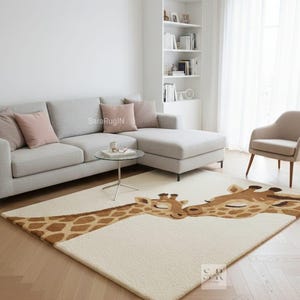May include: A cream-coloured area rug featuring two giraffe heads with brown and tan spots. The giraffes are touching noses, creating a heartwarming design. The rug is placed on a hardwood floor in a living room setting.