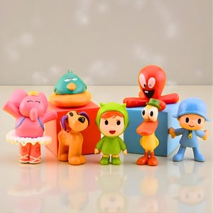 Puede incluir: Colección de figuras coloridas con personajes de dibujos animados. El conjunto incluye un elefante rosa, un perro marrón, una figura vestida de verde, un pato amarillo, una figura azul, un pulpo rojo y un pájaro turquesa.
