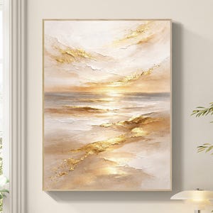 Op de afbeelding: Abstract landschapsschilderij met een gouden zonsondergang boven de oceaan. Het kunstwerk toont getextureerde penseelstreken in goud, beige en wit, waardoor een serene en rustgevende sfeer ontstaat. Het schilderij is ingelijst in een licht houten frame.