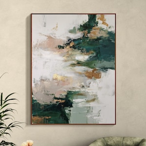 May include: Abstract art painting in a brown frame. The artwork features a blend of colors, including shades of green, white, gold, and pink. The painting has a textured appearance, with visible brushstrokes creating a dynamic and modern aesthetic.