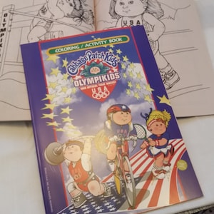 May include: A Cabbage Patch Kids OlympiKids coloring and activity book with illustrations of the dolls participating in various Olympic sports. The cover features the USA Olympic team mascot and the Olympic rings.