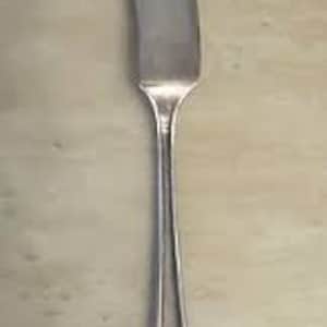 May include: A silver butter knife with a pointed blade and a decorative handle.
