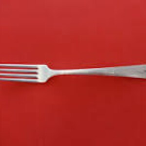 May include: A silver fork with a simple, elegant design. The fork has four tines and a smooth, rounded handle.