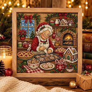 Könnte beinhalten: Ein gerahmtes Kreuzstichbild, das eine Person mit roter Mütze und Schürze beim Verzieren von Lebkuchen in einer Küche zeigt. Die Szene umfasst ein Fenster, einen Kamin, ein Lebkuchenhaus, Schüsseln mit Gebäck und weihnachtliche Dekorationen.