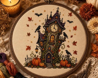 May include: A circular embroidery hoop containing a cross-stitch design of a tall, dark clock tower surrounded by autumn leaves, pumpkins, and black birds. The tower features a clock face, glowing windows, and climbing vines on a cream fabric.