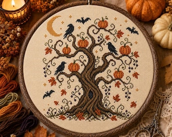 May include: A circular wooden embroidery hoop containing a cross-stitch design of a large brown tree with orange pumpkins, black crows, and bats. The scene includes a yellow crescent moon and scattered autumn leaves on a light beige fabric background.